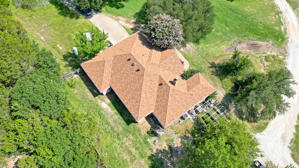 A completed tile-profile roof on a North Texas home, photographed from above, the whole roof plane and every valley visible